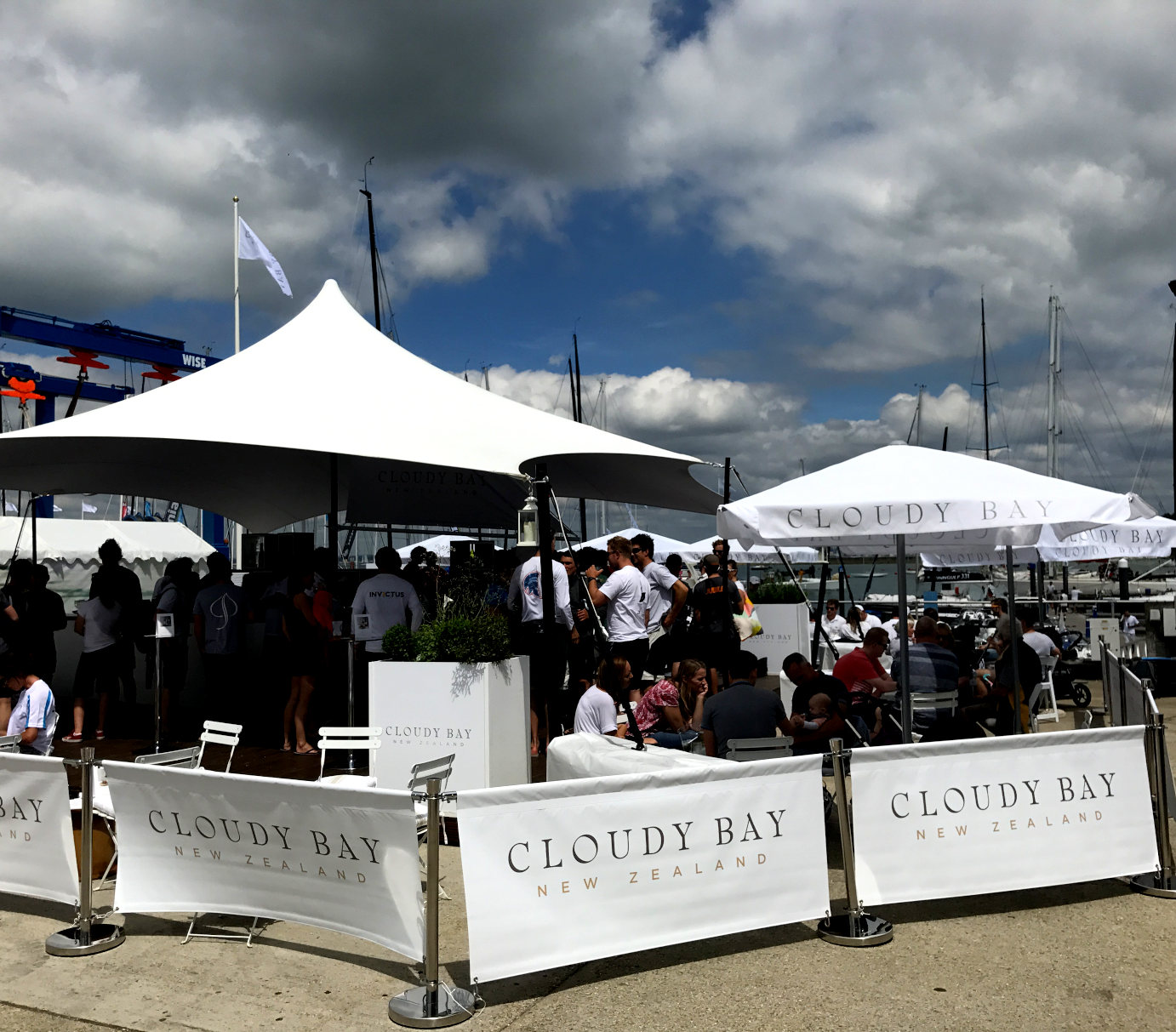 Premium hospitality area at Cowes Week marina with branded event tents and guests