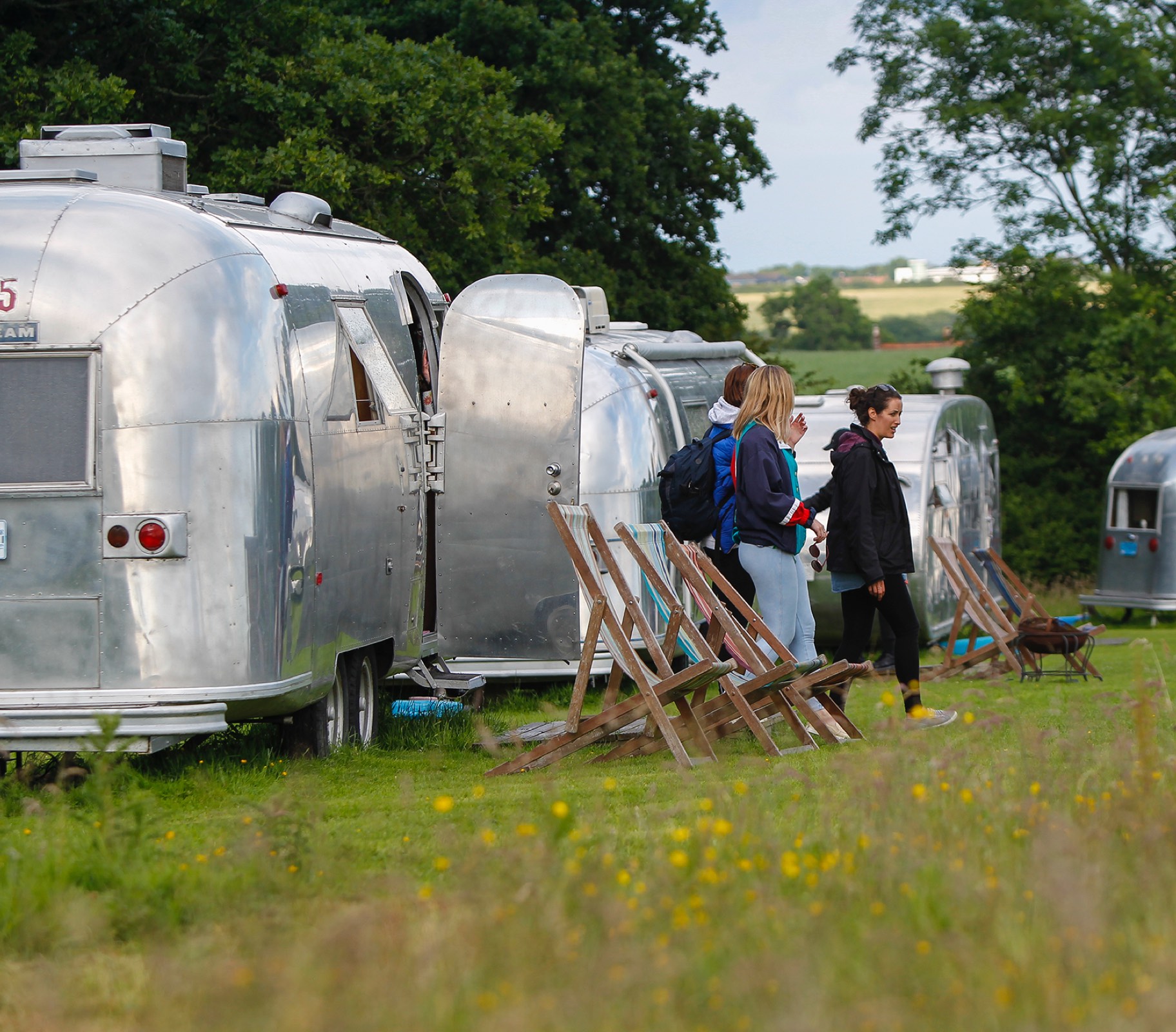 Luxury Airstream trailers and deck chairs set up for corporate glamping experience UK