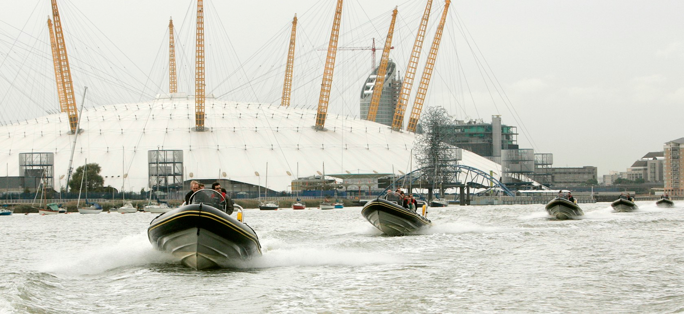 Corporate guests onboard high-speed RIBs on the River Thames with The O2 arena in London in the background during a team event experience