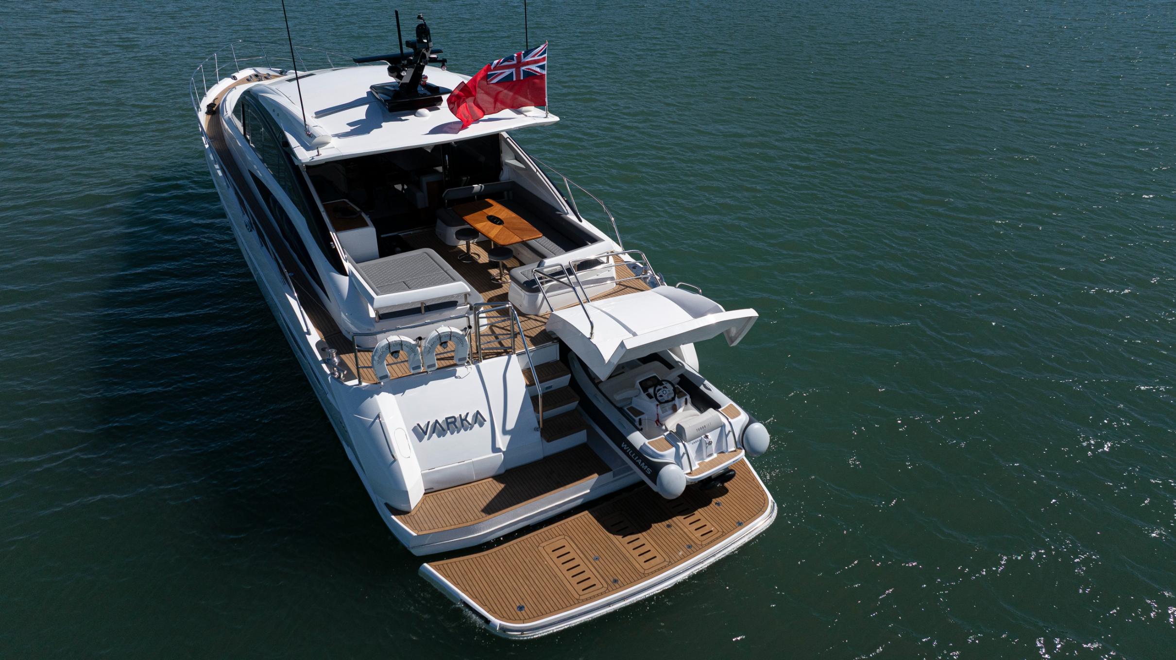 Aerial stern view of Princess V65 Varka luxury motor yacht with swim platform and tender for private yacht charter with Solent Events