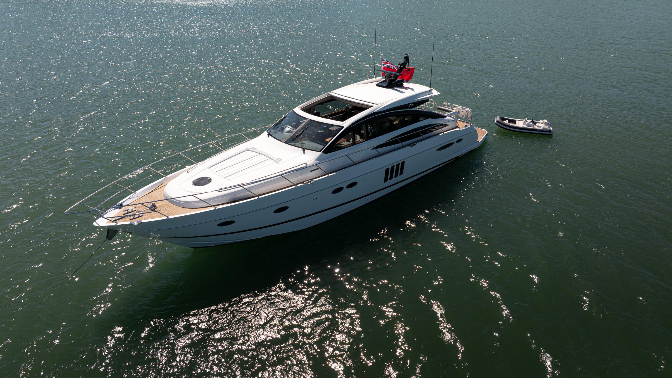 Aerial view of Princess V65 Varka luxury motor yacht anchored on open water with tender alongside for private yacht charter with Solent Events